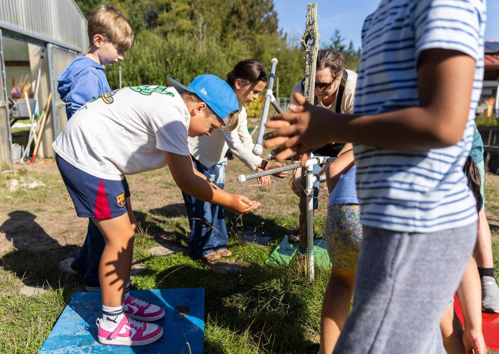 Dylan Blank washes his hands before going to pick vegetables in the garden during class at South Whidbey Elementary School on Sept. 22, 2025 in Langley, Washington. (Olivia Vanni / The Herald)
