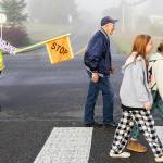 Grandpa Buzz smiles while he crosses the street and greets people along the way as he walks to Cascade View Elementary on Sept. 30, 2025 in Snohomish, Washington. (Olivia Vanni / The Herald)