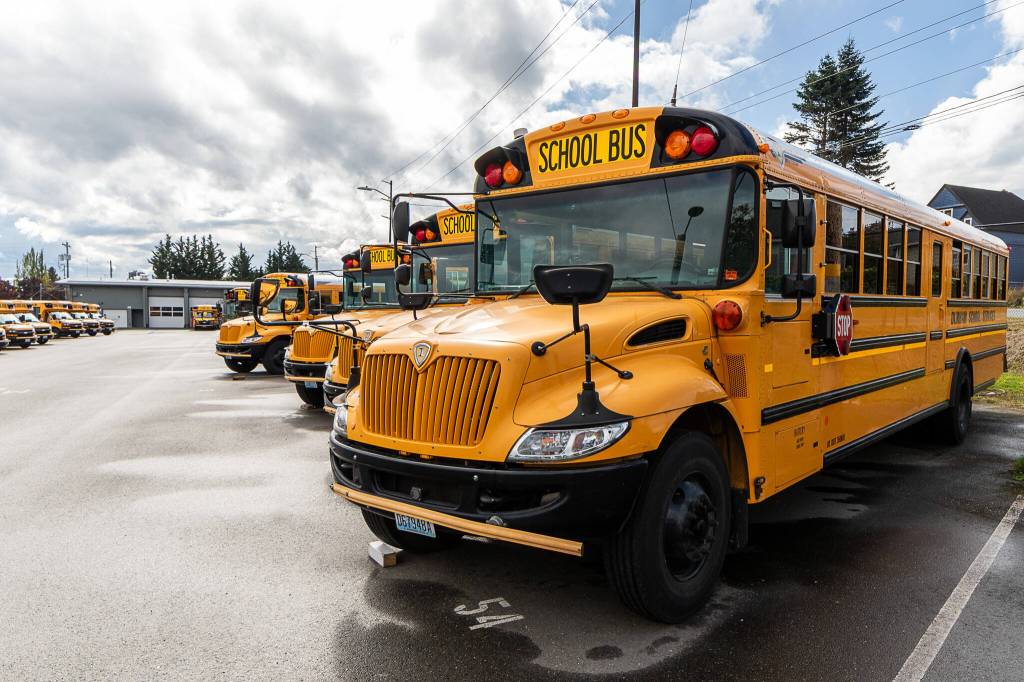 A row of buses sit in an Everett Public Schools lot Wednesday in Everett. Members of the Teamsters Local 38 are in disagreement with Durham School Services over its latest contract. (Aaron Kennedy / The Herald)