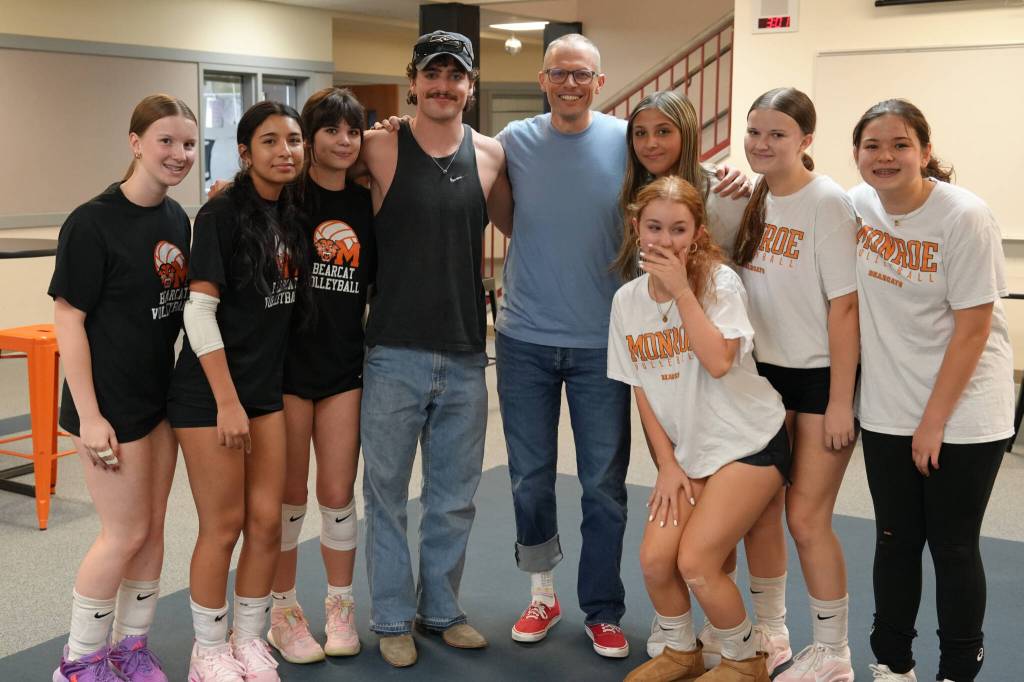 Benson Boone poses for photos with members of the volleyball team during a visit to Monroe High School on Monday, Oct. 6, 2025, in Monroe, Washington. (Monroe School District)