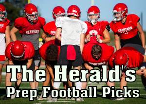 Stanwood's Michael Mascotti relays the next play to his teammates during football practice on Monday, Aug. 29, 2022 in Stanwood, Washington. (Olivia Vanni / The Herald)