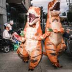 Two people in dinosaur costumes demonstrate against ICE in Portland, Ore., on Friday, Oct. 10, 2025. Images of anarchists clad in black gave the city a bad name in 2020. Now, demonstrators in Portland are poking fun at President Trump’s apocalyptic talk with colorful animal suits. (Jordan Gale/The New York Times)