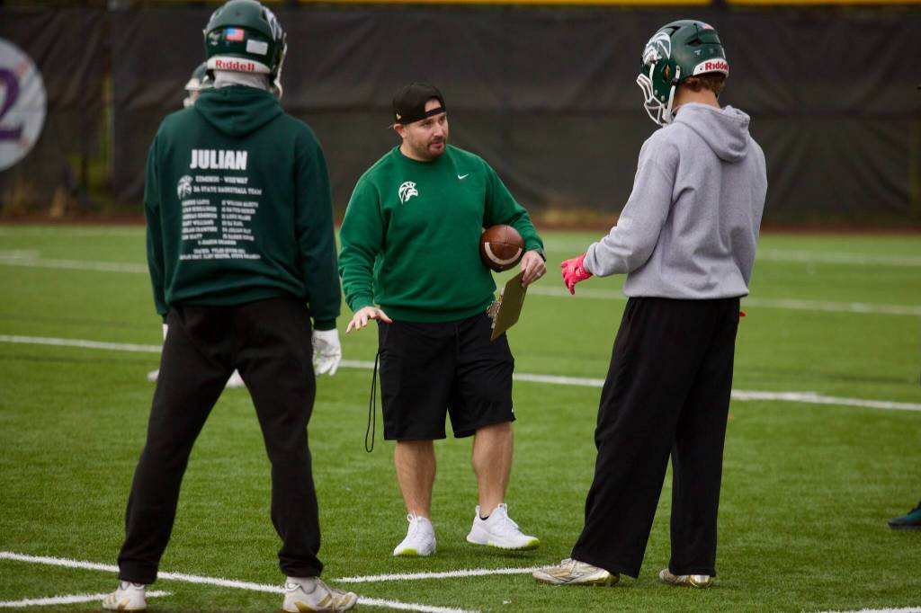 Edmonds-Woodway coach Joe Roth provides instruction to a couple players during a walk-through practice at Edmonds-Woodway High School on Oct. 20, 2025. (Joe Pohoryles / The Herald)