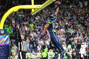 Seahawks wide receiver Jaxon Smith-Njigba dunks a football over the goalpost crossbar after scoring a touchdown against the Houston Texans Oct. 20, 2025, on Monday Night Football at Lumen Field in Seattle, Washington. (Photo courtesy of the Seattle Seahawks)
