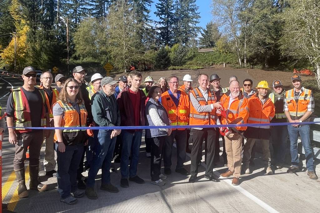 County Council member Nate Nehring cuts the ribbon with Executive Operations Officer Josh Dugan, celebrating on Tuesday with the crew that worked on the new Jordan Creek Bridge. (Provided photo)