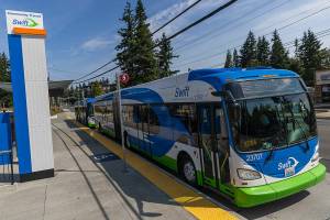 Two Swift Orange Line buses wait at the Edmonds College Transit Center on Friday, Aug. 1, 2025 in Lynnwood, Washington. (Olivia Vanni / The Herald)