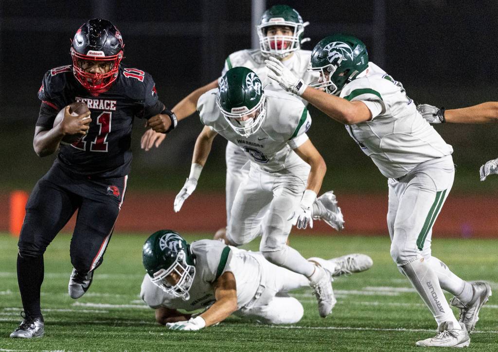 Mountlake Terraces Mason Wilson escapes multiple tackles as he runs the ball up the field during the game against Edmonds-Woodway on Oct. 23, 2025 in Edmonds, Washington. (Olivia Vanni / The Herald)