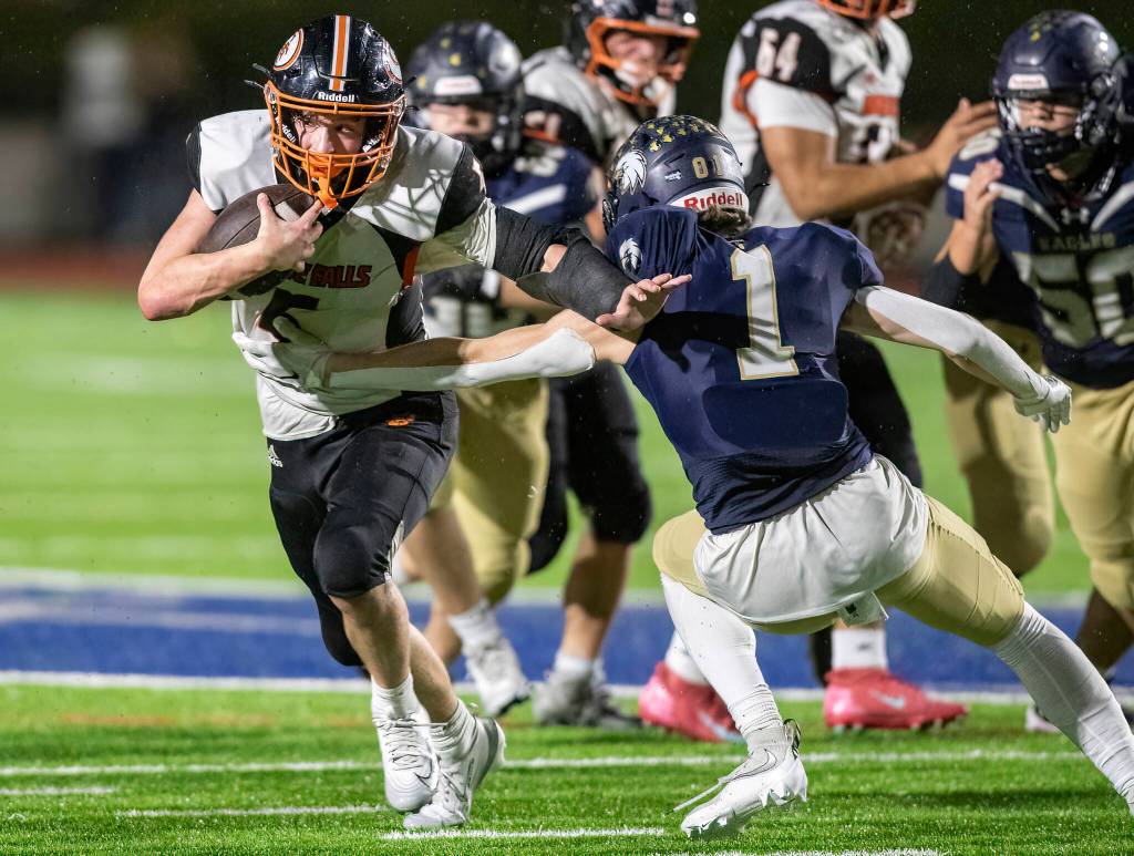 Granite Falls Beau Everson sticks his arm out to block a tackle by Cedar Park Christians Lyal Viers during the game on Oct. 24, 2025 in Kirkland, Washington. (Olivia Vanni / The Herald)