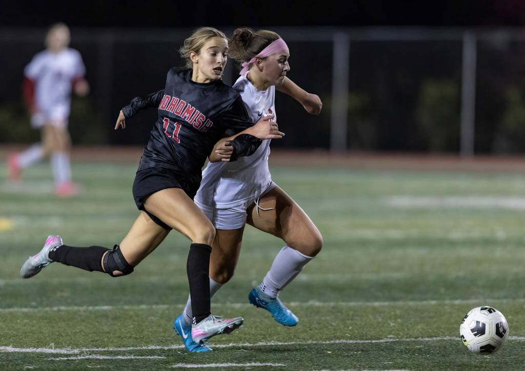 Snohomishs Jenna Pahre and Stanwoods Kayla Frydenlund grab each others arms as they run after the ball during the game on Oct. 27, 2025 in Snohomish, Washington. (Olivia Vanni / The Herald)