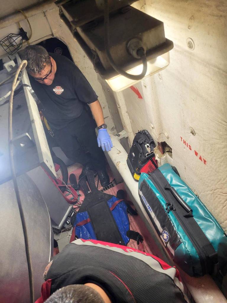 First responders navigate a confined space to treat an unresponsive patient found behind the boiler of a docked ferry on Tuesday, Oct. 28, 2025, in Everett, Washington. (Everett Fire Department)
