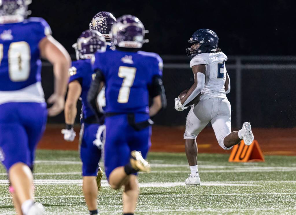 Arlingtons Dirci Ngondo runs the ball upfield into the end zone for a touchdown during the game against Lake Stevens on Oct. 31, 2025 in Lake Stevens, Washington. (Olivia Vanni / The Herald)