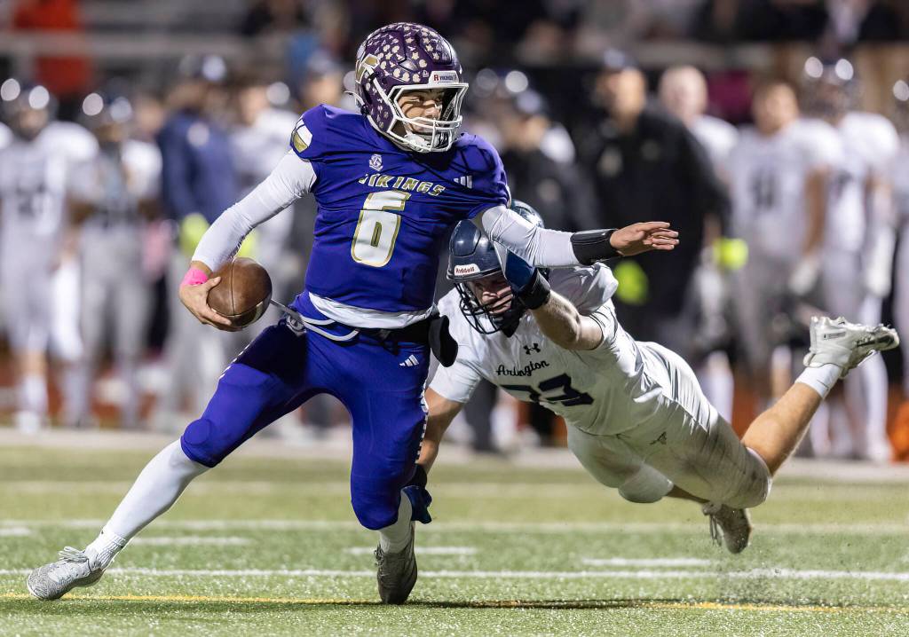 Lake Stevens Blake Moser escapes a tackle by Arlingtons Jace Graham during the game on Oct. 31, 2025 in Lake Stevens, Washington. (Olivia Vanni / The Herald)