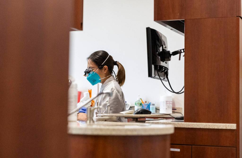 Managing Dentist Dr. Lily Lou speaks with a patient on Oct. 28, 2025 in Lynnwood, Washington. (Olivia Vanni / The Herald)