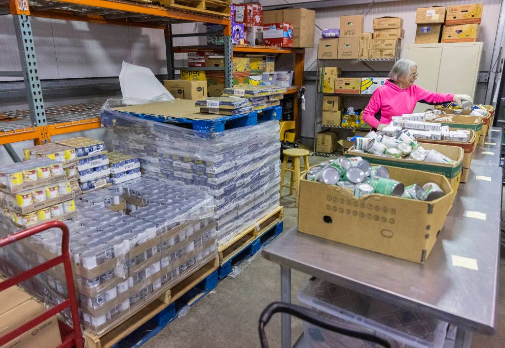 Lynnwood Food Bank volunteer Donna Leggett organizes canned goods on Oct. 29, 2025 in Lynnwood, Washington. (Olivia Vanni / The Herald)