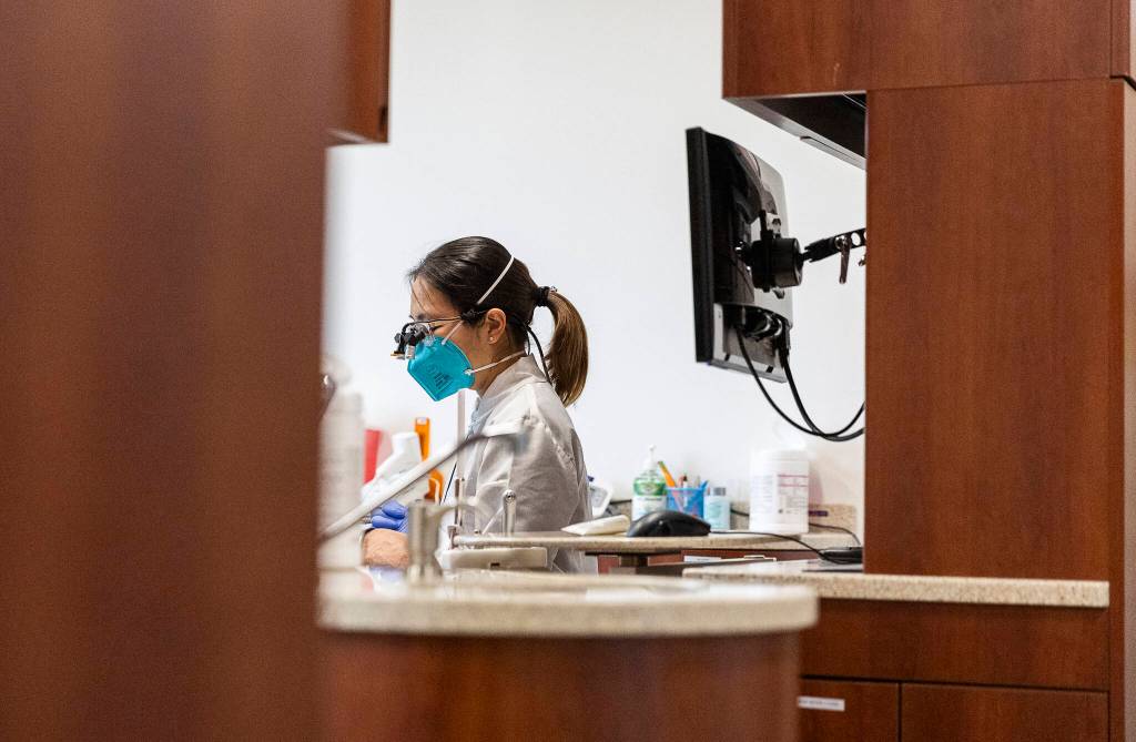 Managing Dentist Dr. Lily Lou speaks with a patient on Oct. 28 in Lynnwood. (Olivia Vanni / The Herald)