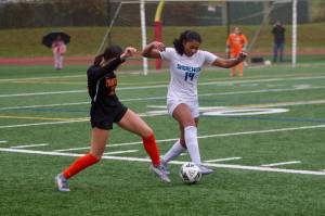 Shorewood senior Jasmyn Jacobs (right) lunges towards a 50/50 ball against Monroe junior Ella Glynn during the Stormrays' 1-1 (4-2 penalty kicks) match against the Bearcats in the District 1 3A quarterfinals at Monroe High School on Nov. 1, 2025. (Joe Pohoryles / The Herald)