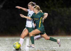 Edmonds-Woodway’s Abby Peterson and Shorecrest’s Cora Quinn run after the ball during the game on Sept. 23, 2025 in Shoreline, Washington. (Olivia Vanni / The Herald)