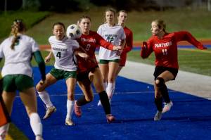 Snohomish junior Danica Avalos (8 in red) and Edmonds-Woodway junior Akiko Ikegami (4 in white) jostle to win possession of a throw-in during the Panthers' 2-0 win against the Warriors in the District 1 3A semifinals at Shoreline Stadium on Nov. 4, 2025. (Joe Pohoryles / The Herald)