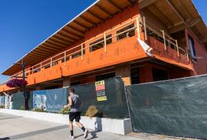 A runner jogs past construction in the Port of Everetts Millwright District on Tuesday, July 15, 2025 in Everett, Washington. (Olivia Vanni / The Herald)