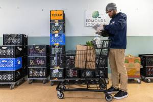 Lester Almanza, programs manager at the Edmonds Food Bank, puts together a custom shoppers order on Wednesday, March 26, 2025 in Edmonds, Washington. (Olivia Vanni / The Herald)