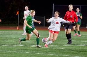 Edmonds-Woodway junior Audrey Rothmier (left) fights for a 50/50 ball against Silas sophomore Allison Conn during the Warriors' 1-0 overtime loss to the Rams in the 3A Girls State Soccer Play-in Round at Edmonds Stadium on Nov. 12, 2025. (Joe Pohoryles / The Herald)