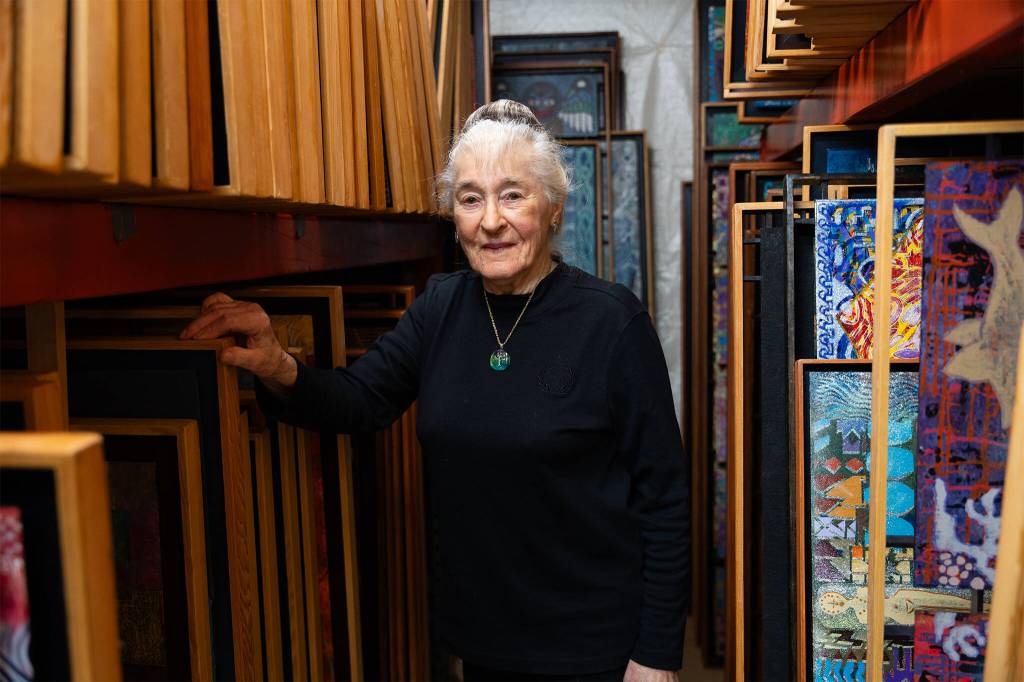 Photos by Will Geschke / The Herald
dElaine Herard Johnson poses for a portrait next to hundreds of her paintings in her home on Wednesday in Edmonds.
