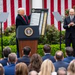 FILE — President Donald Trump and Secretary of Commerce Howard Lutnick display a chart detailing tariffs, at the White House in Washington, on Wednesday, April 2, 2025. The Justices will hear arguments on Wednesday, Nov. 5, 2025 over whether the president acted legally when he used a 1977 emergency statute to unilaterally impose tariffs.(Haiyun Jiang/The New York Times)