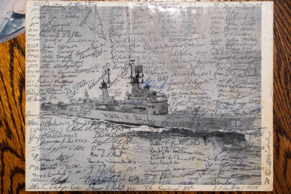 A photo of the USS Belknap, signed by crew members, at Roger Sharps Marysville home. (Will Geschke / The Herald)