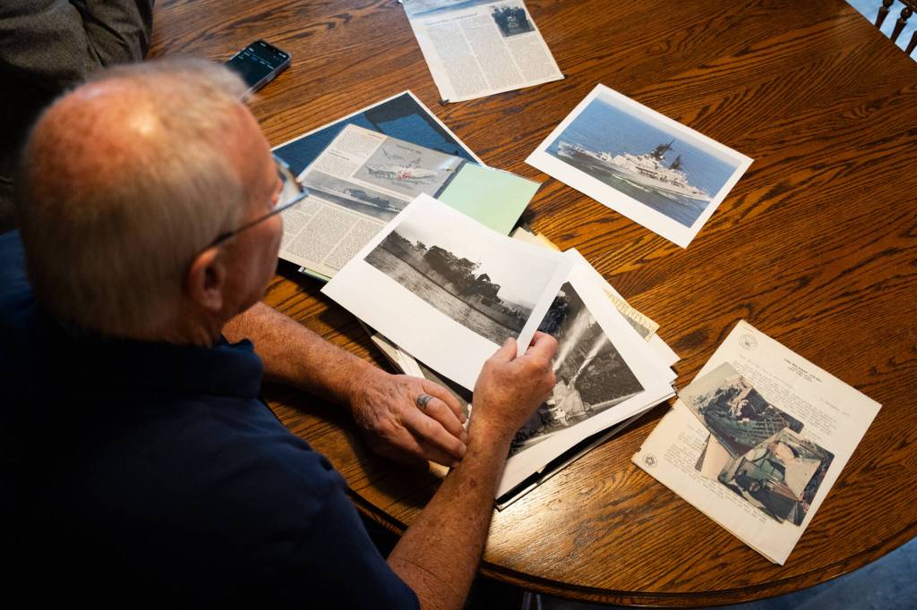 Roger Sharp looks over memorabilia from the USS Belknap in his home in Marysville on Nov. 14, 2025. (Will Geschke / The Herald)