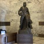 A bronze statue of Marcus Whitman in the Washington state Capitol building weighs over 9,000 pounds with its stone base. (Jacquelyn Jimenez Romero / Washington State Standard)