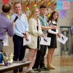Arlington junior Ramon Little (second from right, in green) stands between fellow team award-winners (from left to right) senior Caden Mace, senior Reaonna Rice and junior Anabelle Klein at the Arlington cross country banquet in the Arlington High School Commons on Nov. 18, 2025. (Joe Pohoryles / The Herald)