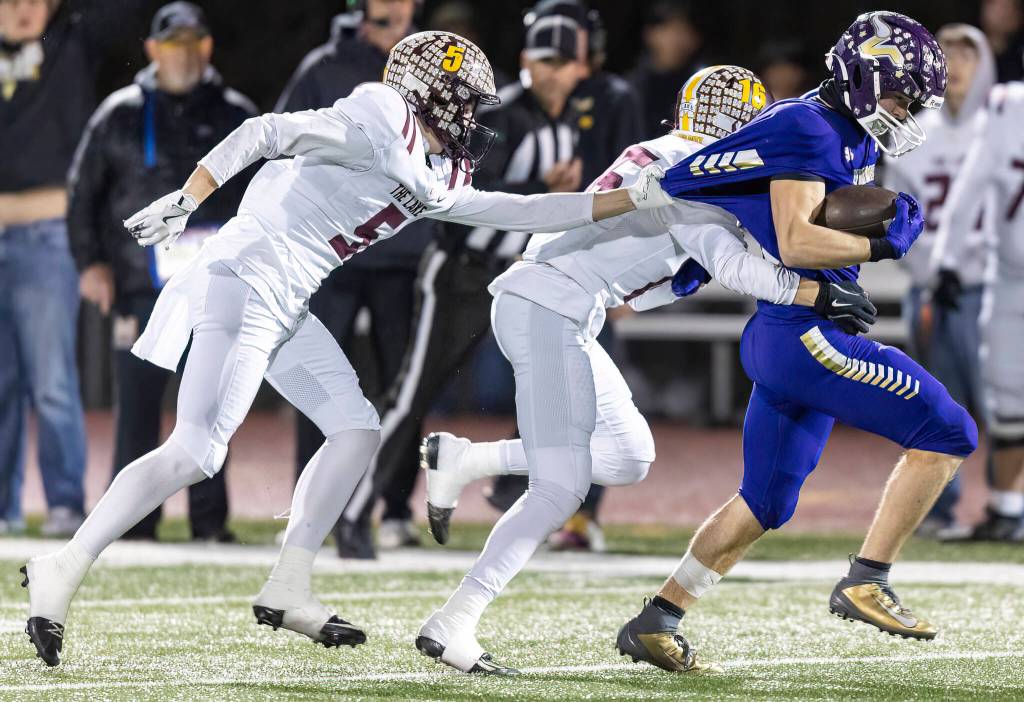 Lake Stevens Greyson Eggers has his jersey pulled as he runs the ball upfield during the 4A state football quarterfinal game against Moses Lake on Nov. 22, 2025 in Lake Stevens, Washington. (Olivia Vanni / The Herald)