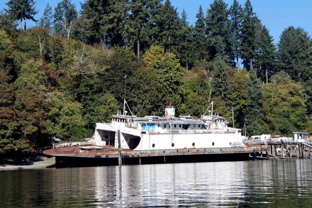 The former state ferry Olympic was declared a public nuisance by Pierce County as far back as 2010. The elderly owner has broken numerous agreements to remove it. It’s still decaying on his beach on Ketron Island. (Photo by Tom Banse for Washington State Standard)