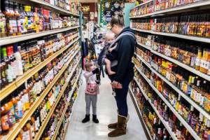 Elizabeth Ferrari, left, hands her mom Noelle Ferrari her choice of hot sauce from the large selection at Double DD Meats on Wednesday, Jan. 11, 2023 in Mountlake Terrace, Washington. (Olivia Vanni / The Herald)