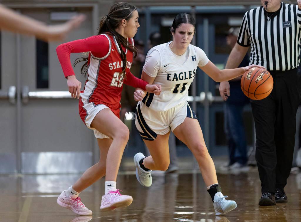 Arlingtons Addi Green dribbles the ball up the court while being guarded by Stanwoods Georgia Lenz during the game on Dec. 3, 2025 in Arlington, Washington. (Olivia Vanni / The Herald)