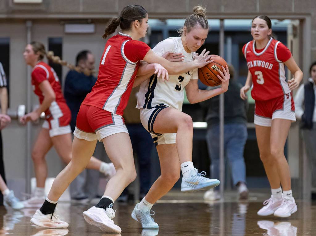 Stanwoods Dorothy Barrett knocks the ball out of the hands of Arlingtons Basia Pszonka during the game on Dec. 3, 2025 in Arlington, Washington. (Olivia Vanni / The Herald)