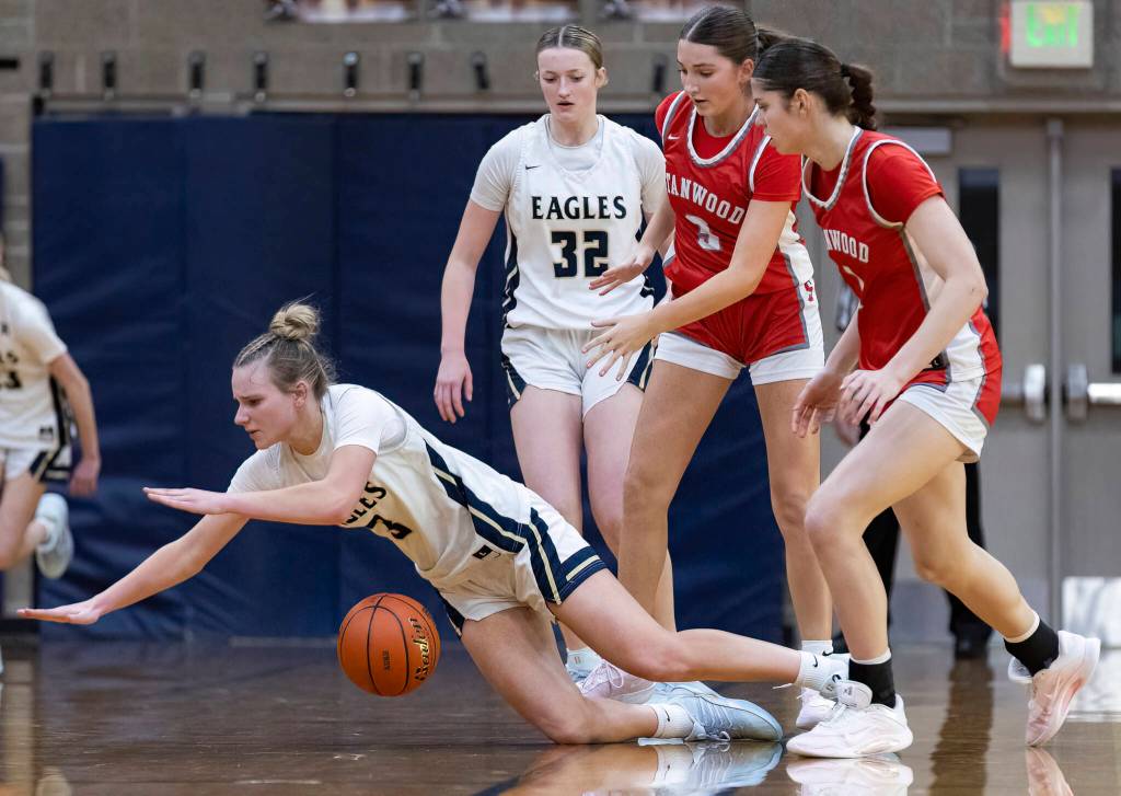 Arlingtons Basia Pszonka is dropped while taking the ball up the court during the game against Stanwood on Dec. 3, 2025 in Arlington, Washington. (Olivia Vanni / The Herald)