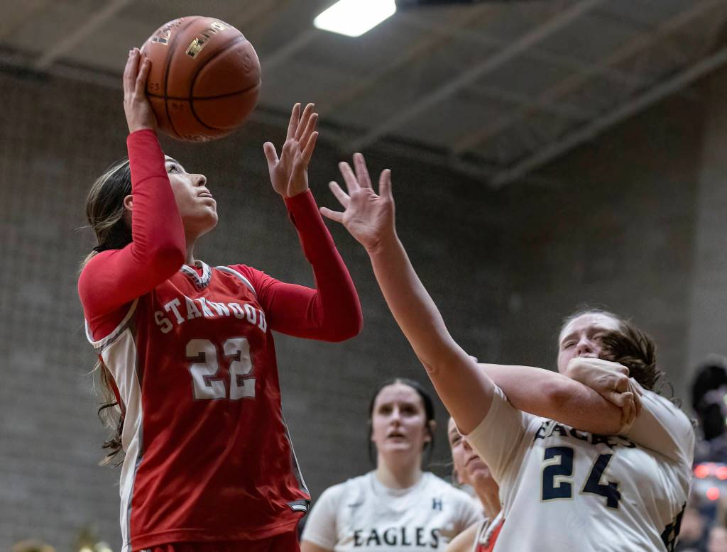 Arlingtons Sami Jones is fouled while trying to guard Stanwoods Georgia Lenz during the game on Dec. 3, 2025 in Arlington, Washington. (Olivia Vanni / The Herald)