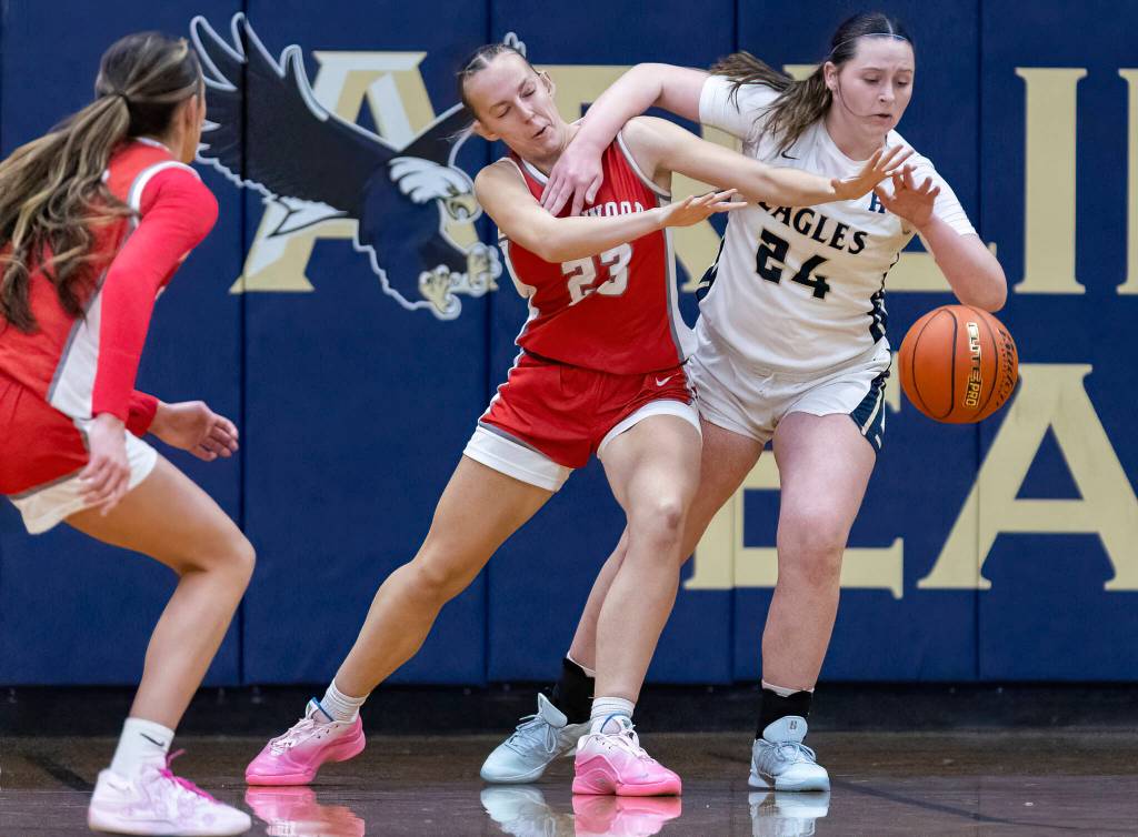 Arlingtons Sami Jones and Stanwoods Camrie Ingram run after a loose ball during the game on Dec. 3, 2025 in Arlington, Washington. (Olivia Vanni / The Herald)