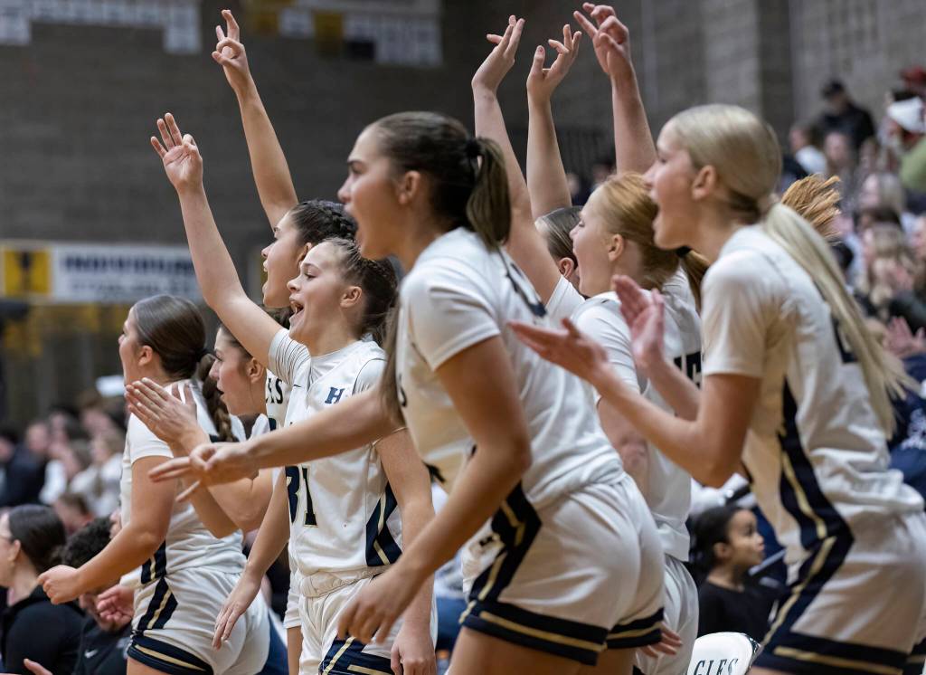 The Arlington bench reacts to a three-point shot during the game against Stanwood on Dec. 3, 2025 in Arlington, Washington. (Olivia Vanni / The Herald)