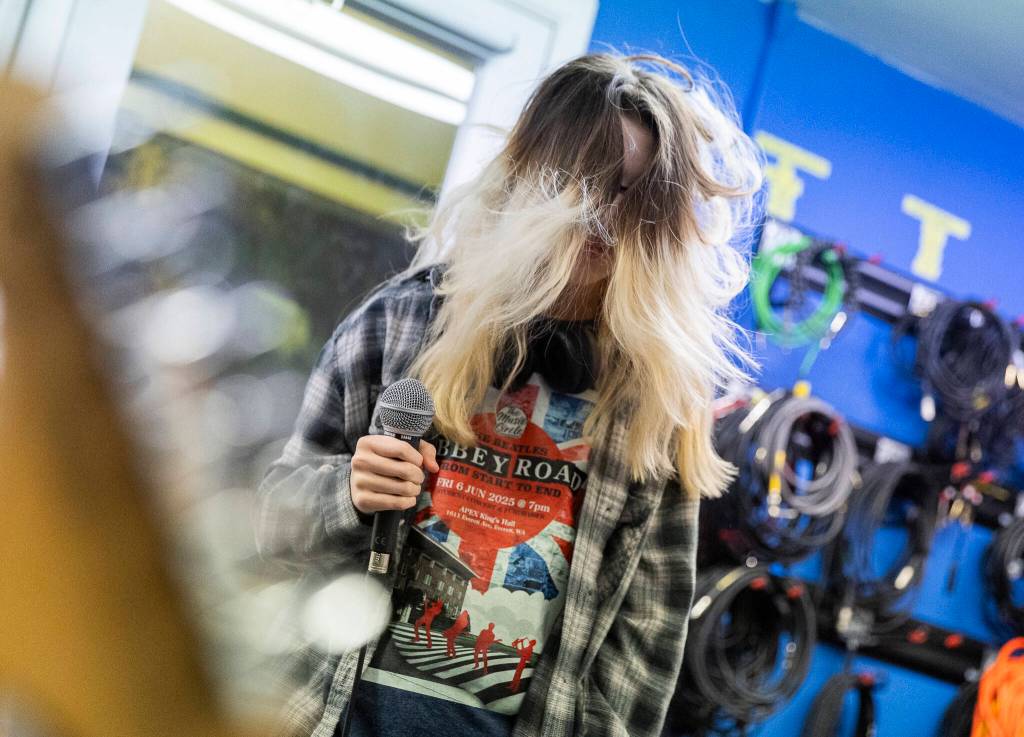 Heather Handyside, 13, head bangs while performing a song during a group lesson at The Music Circle on Dec. 1, 2025, in Everett, Washington. (Olivia Vanni / The Herald)