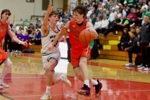 Monroe sophomore Isaiah Kiehl drives the ball down against Edmonds-Woodway junior DJ Karl in the Bearcats 61-56 win against the Warriors in the District 1 3A Boys Basketball Championship in Marysville, Washington on Feb. 22, 2025. (Joe Pohoryles / The Herald)