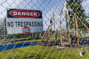 A “danger” sign hangs on the fence surrounding the recently burned Wiggums Hollow playground on Nov 19 in Everett. (Olivia Vanni / The Herald)