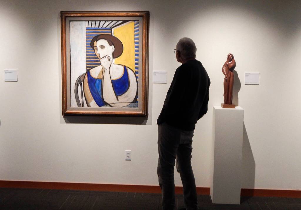 A visitor to Cascadia Art Museum takes in a Clayton James portrait of a woman on Sept. 12, in Edmonds, Wash. (Jon Bauer / The Herald)