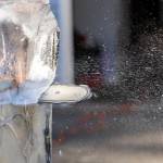 A chain saw sprays ice and water as Kitburi carves large ice chunks out of his sculpture on Sept. 17, 2025 in Marysville, Washington. (Olivia Vanni / The Herald)