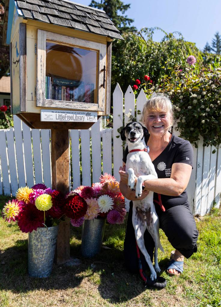 Anne Maria Jacobson next to her Little Free Library on Sept. 16, 2025 in Everett. (Olivia Vanni / The Herald)