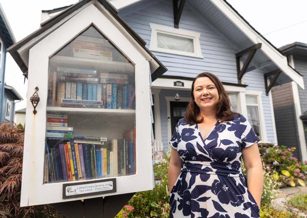 Nikki Lehosky with her Little Free Library on Sept. 4, 2025 in Everett. (Olivia Vanni / The Herald)
