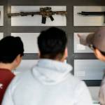 Customers look at AR-15-style rifles on a mostly empty display wall at Rainier Arms Friday, April 14, 2023, in Auburn, Wash. as stock dwindles before potential legislation that would ban future sale of the weapons in the state. House Bill 1240 would ban the future sale, manufacture and import of assault-style semi-automatic weapons to Washington State and would go into immediate effect after being signed by Gov. Jay Inslee. (AP Photo/Lindsey Wasson)