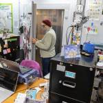 Edmonds Food Bank Executive Director Casey Davis opens up a door to one of their fridges that is only accessible through their makeshift office space on Monday, Dec. 8, 2025 in Edmonds, Washington. (Olivia Vanni / The Herald)