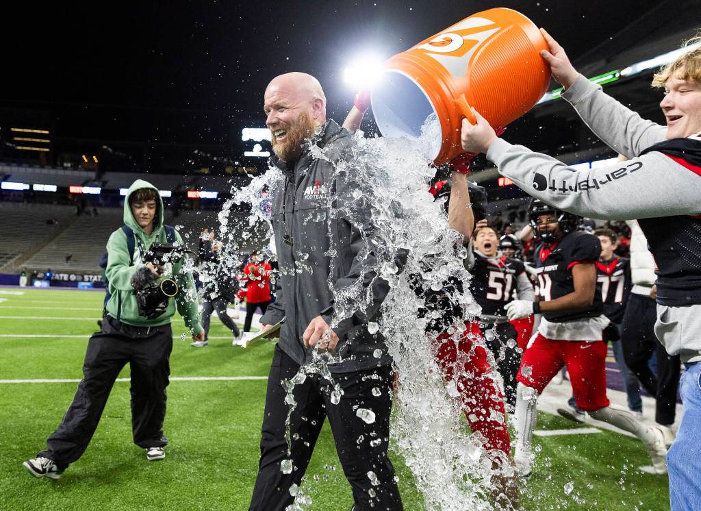 Archbishop Murphy head coach Joe Cronin has ice water dumped on him after winning the 2A state championship game against Tumwater at Husky Stadium on Saturday, Dec. 6, 2025 in Seattle, Washington. (Olivia Vanni / The Herald)